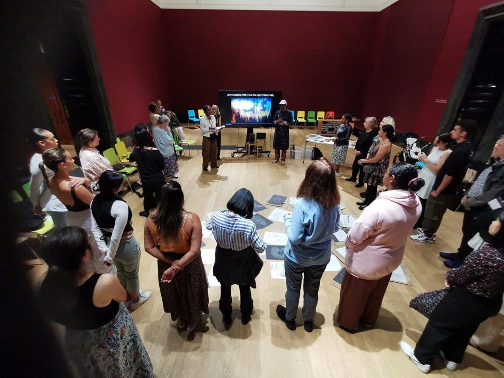 A large group standing in a circle during a community session