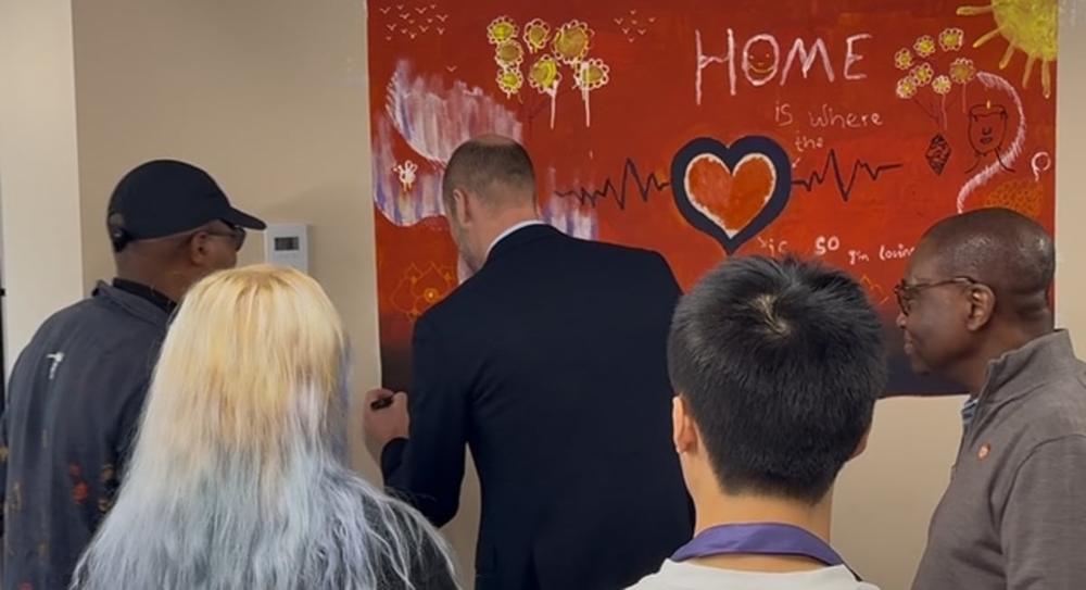Guests beside the painted 'Home' mural