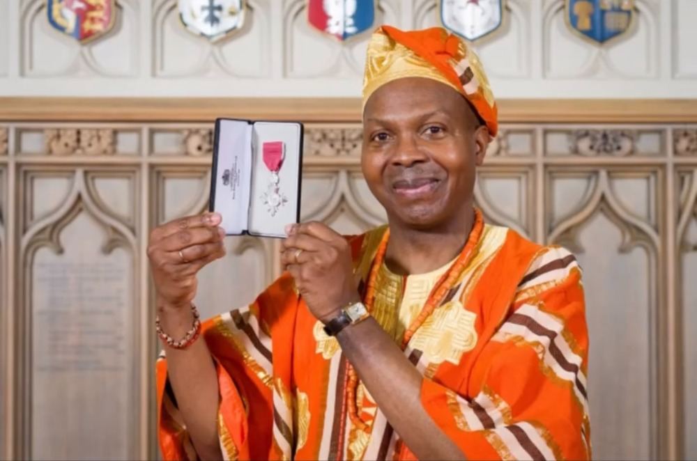 Lanre Olagoke holding his MBE medal
