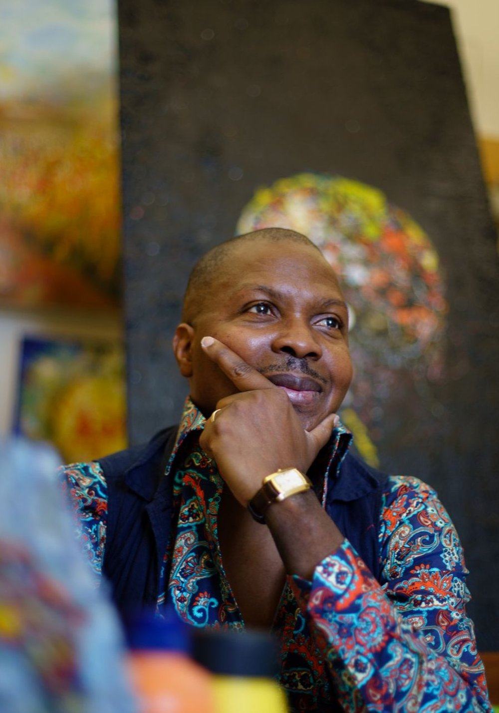 Lanre Olagoke MBE in his studio, surrounded by paintings
