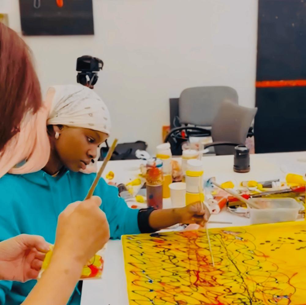 A young participant painting with bright colours