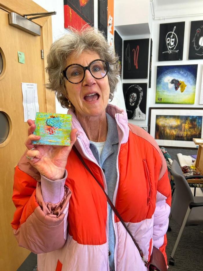 Venetia Findlay holding a small artwork in the studio